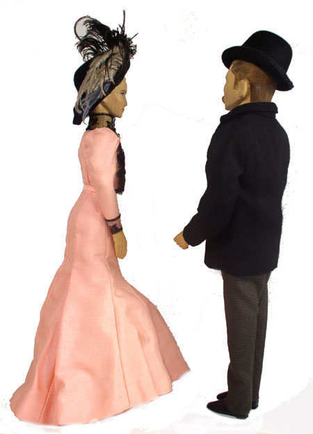 Back view of husband and wife wooden dolls dressed in period costumes of America in 1900