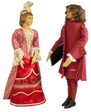 Front view of husband and wife wooden dolls dressed in period costumes of America in 1708